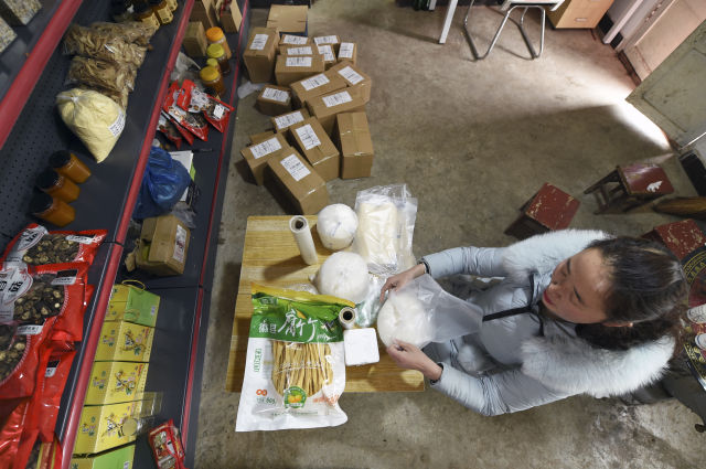 　　2月19日，在位于甘肃省陇南市徽县水阳镇石滩村的家中，梁倩娟为买家打包货物。她开办“陇上庄园”网店，将当地出产的农产品通过网络销售，带动了乡亲们脱贫增收。